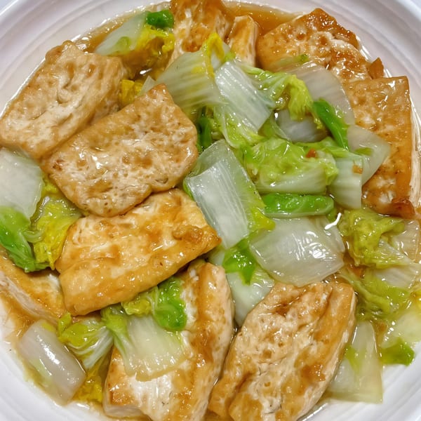 Chef Wang's braised tofu and bok choy in a savory sauce, served in a white bowl.