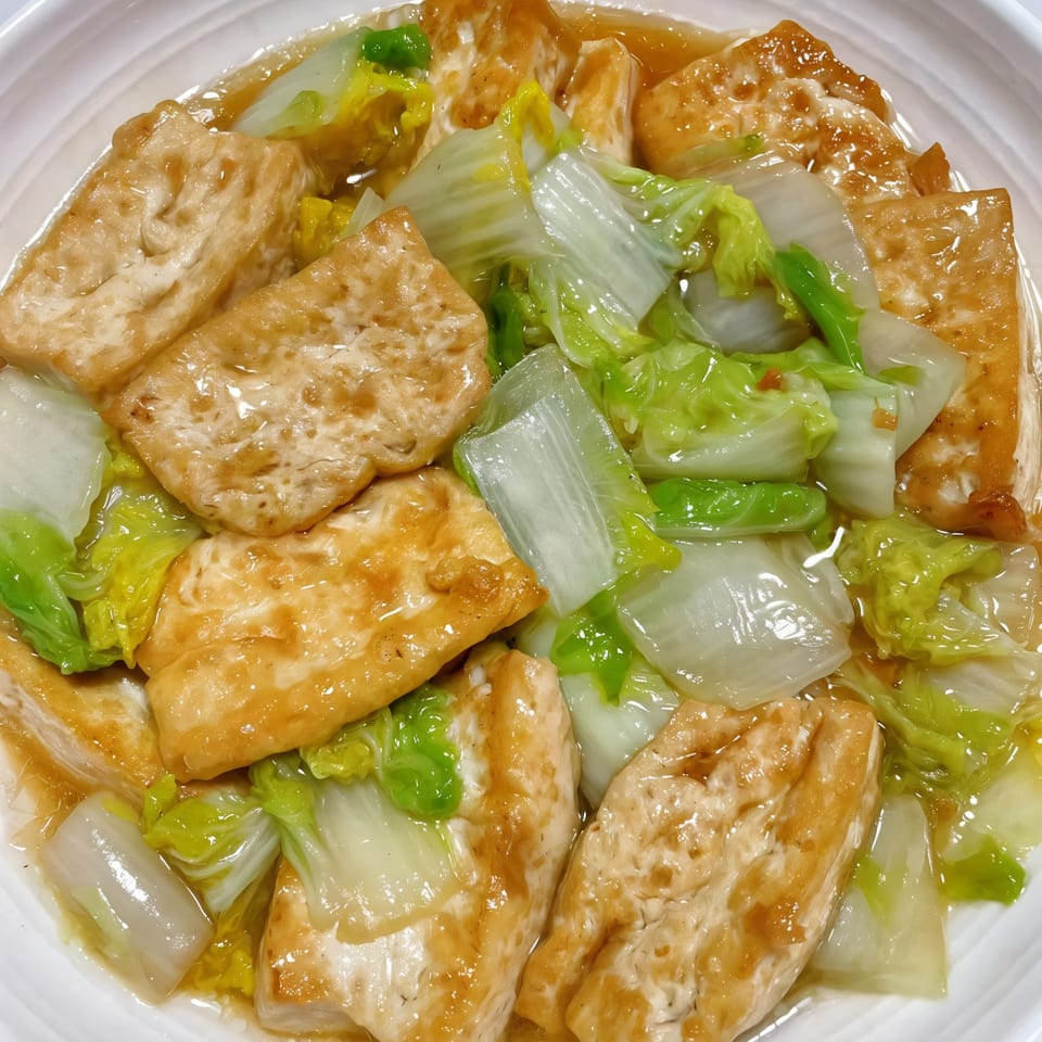 Chef Wang's braised tofu and bok choy in a savory sauce, served in a white bowl.