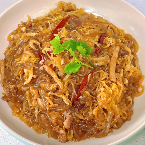 Chef Wang's Chinese dish of glass noodles, shredded cabbage, meat, red chilies, and cilantro.