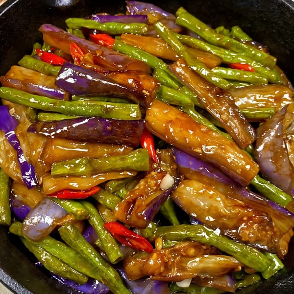 Stir-fried Chinese eggplant and green beans with red chilies in a glossy brown sauce.
